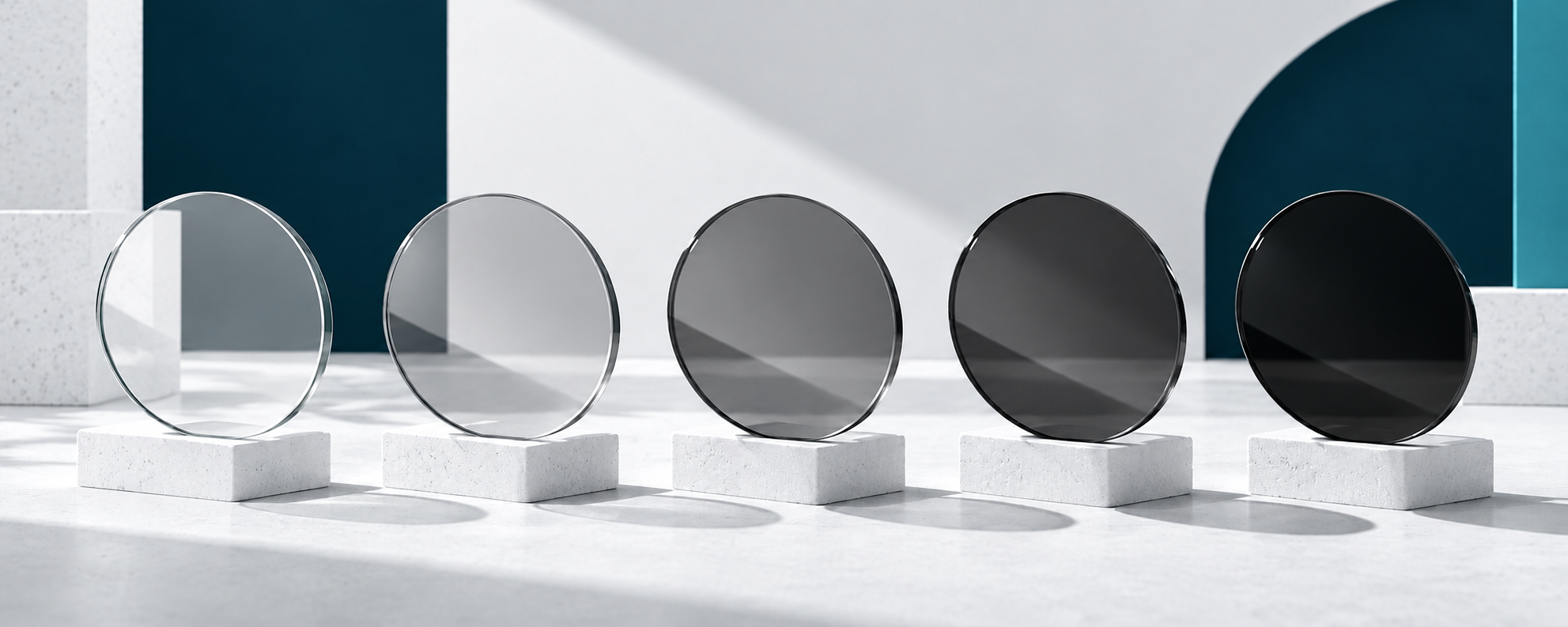 Five circular lenses in a conceptual progression from almost clear to very dark grey