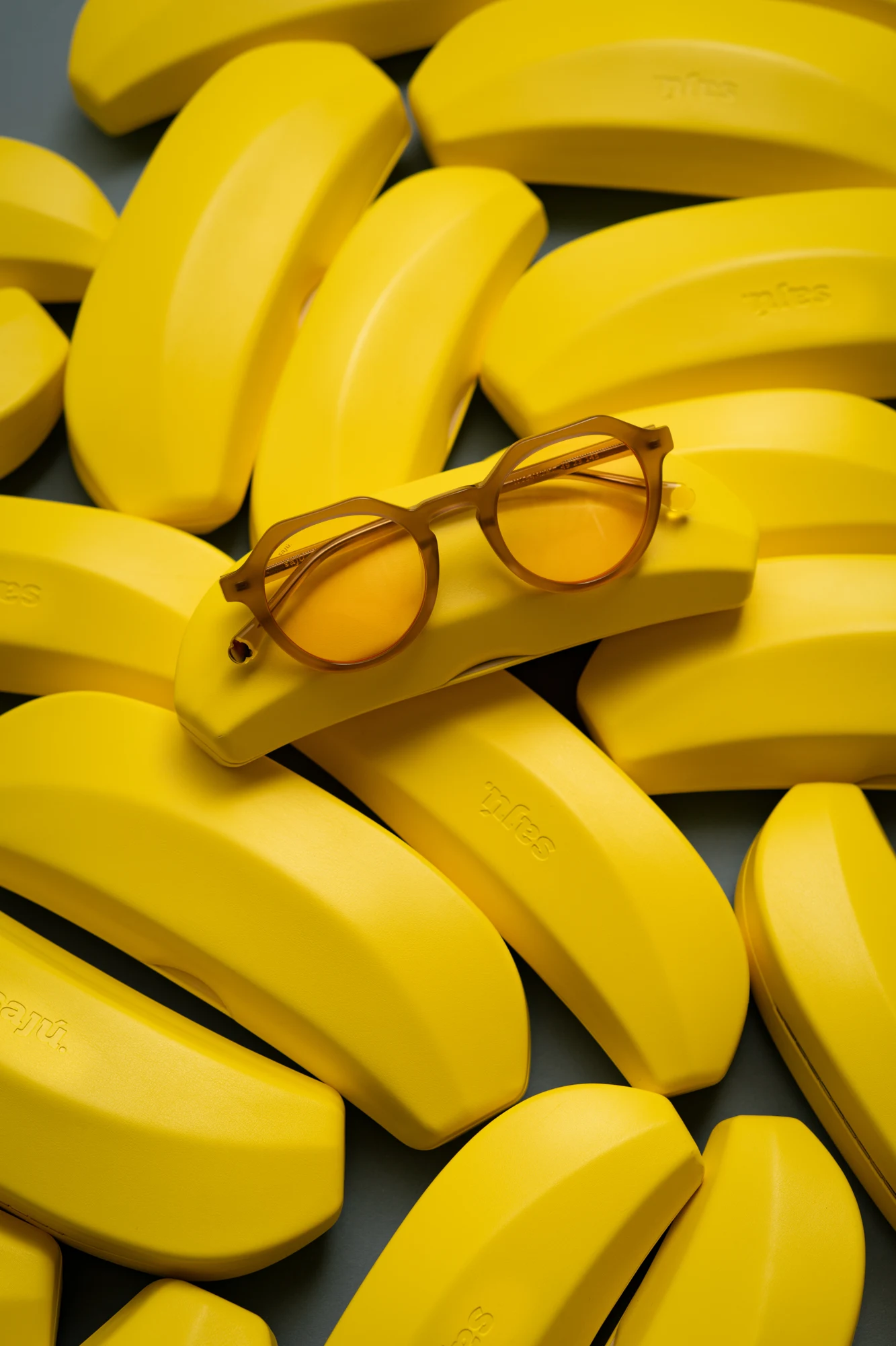 Banana Case gialli insieme a un paio di occhiali nella campagna Sajú