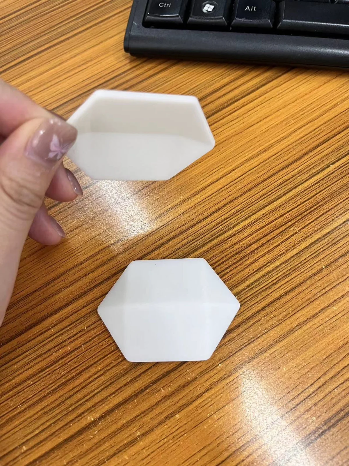 Two white polygonal end pieces from the case development archive