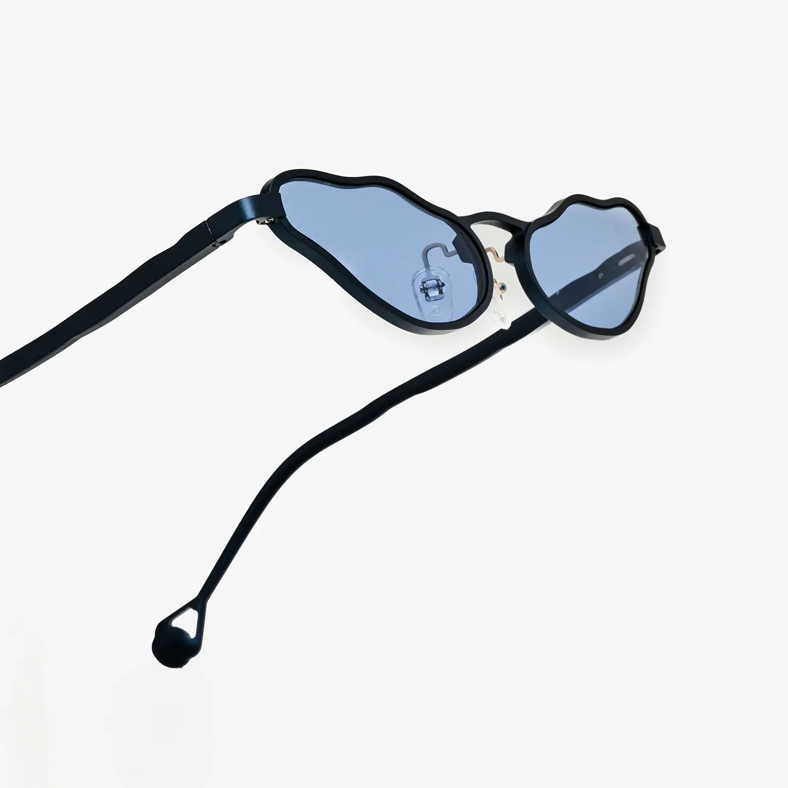 Three-quarter view of the finished navy frame, blue lenses, nose pads and custom temple tips