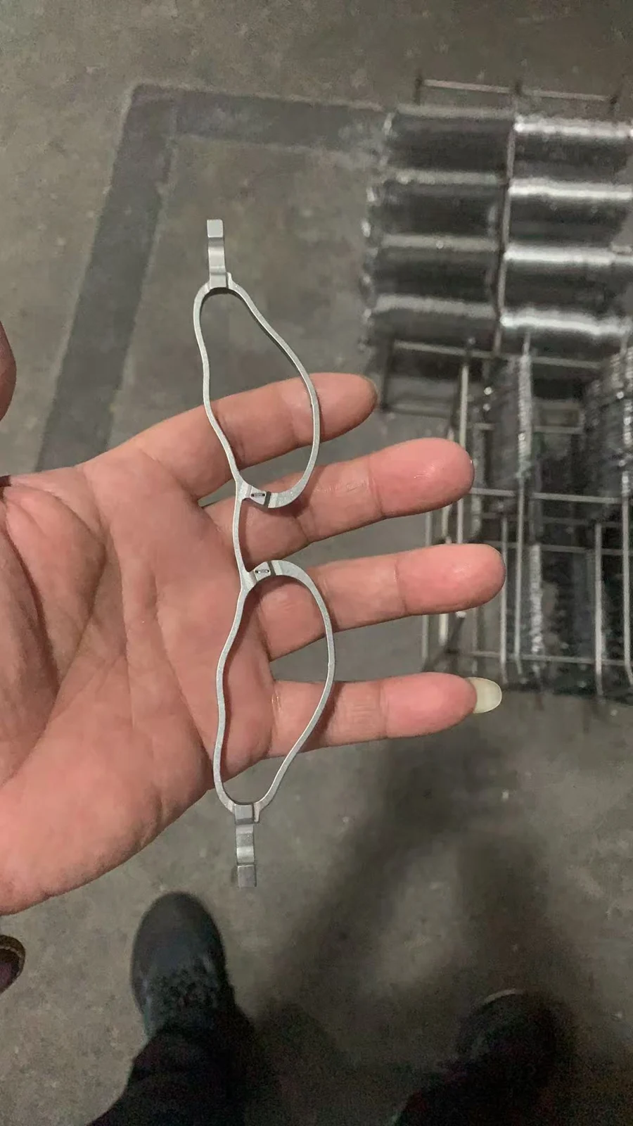 Unfinished metal front held in the hand during eyewear development