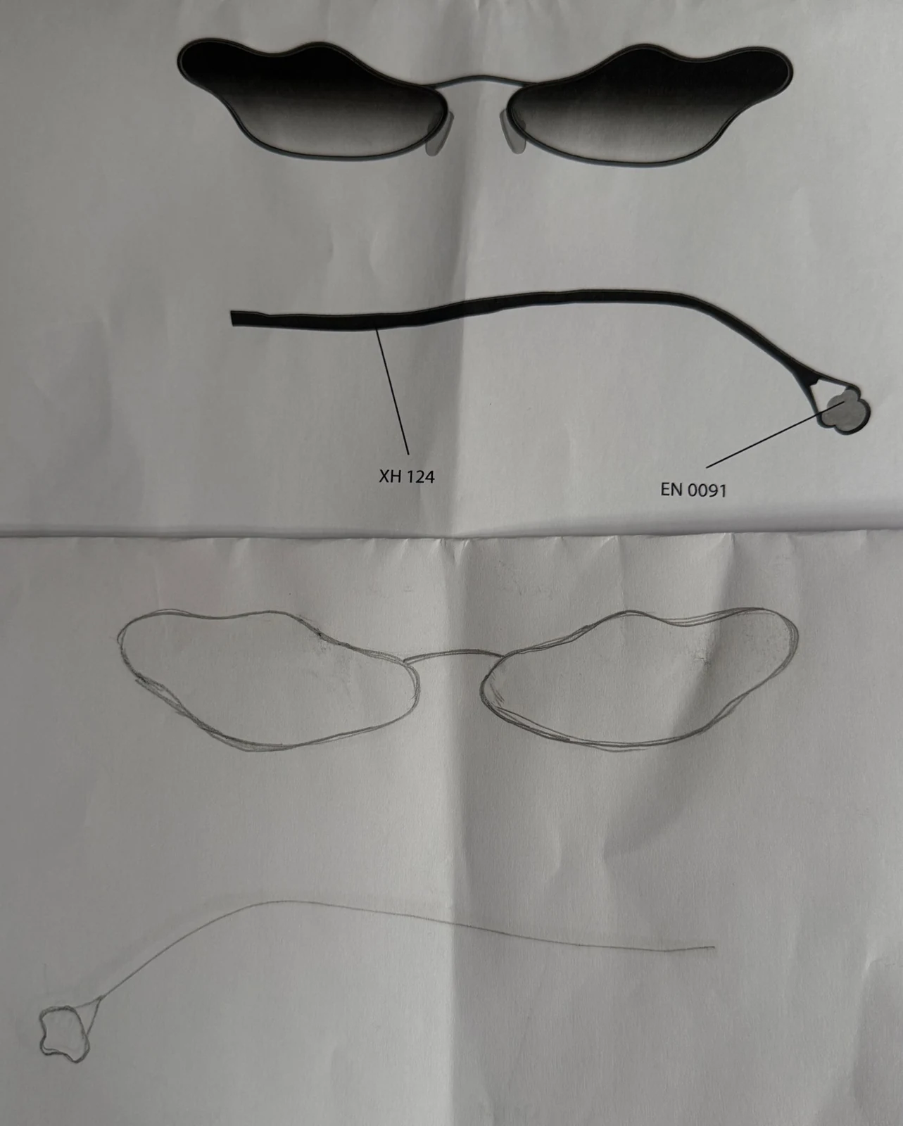 Project archive photograph showing pencil outlines alongside a printed eyewear proposal